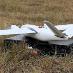 White, remote-sensing drone in field